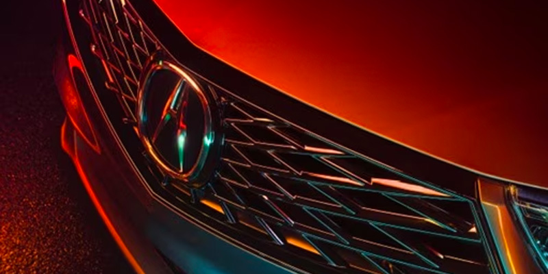 Close-up of an Acura SUV's front grille showcasing a shiny logo and intricate details.