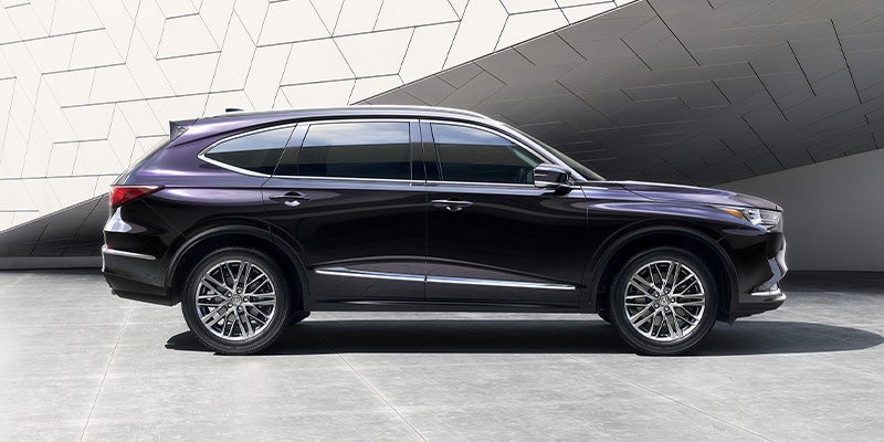 side view of a dark 2025 Acura MDX parked on a road